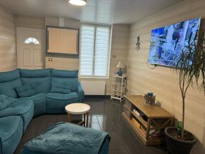 ein Wohnzimmer mit einem blauen Sofa und einem Tisch in der Unterkunft L'ESCALE in Le Portel