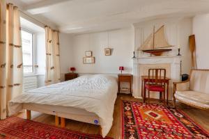 um quarto com uma cama, uma cadeira e uma lareira em Parenthese a 20m de la baie de Quiberon em Saint-Pierre-Quiberon