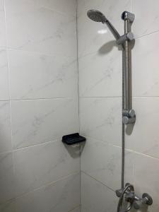 La salle de bains est pourvue d'une douche avec un pommeau de douche. dans l'établissement City Appartementen New Nickerie - 2p, à Nieuw Nickerie