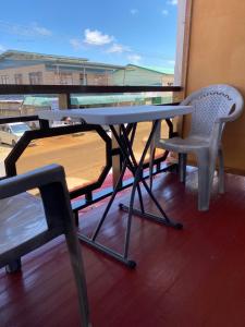 une table et deux chaises assises sur un balcon dans l'établissement City Appartementen New Nickerie - 2p, à Nieuw Nickerie