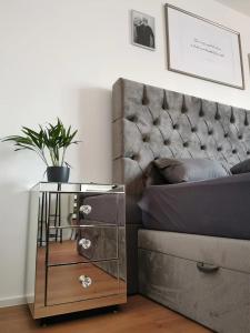 a night stand next to a bed with a plant on it at Z8 Living in Hannover
