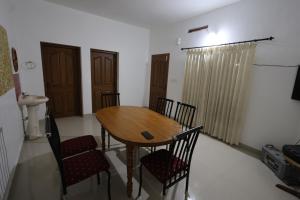 jadalnia z drewnianym stołem i krzesłami w obiekcie Wayanad regal residency w mieście Kalpatta