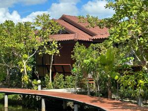 a house with a bridge in front of it at The Beatles Lagoon in Ban Na Bon