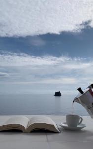 un livre ouvert et une tasse de café sur une table dans l'établissement Casa Francesca, à Stromboli