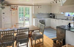 een keuken met een houten tafel en stoelen bij Lovely Home In Grsbo With Kitchen 