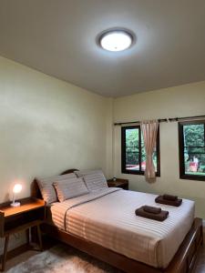 - une chambre avec un lit et 2 fenêtres dans l'établissement ViangPhing Resort, à Mae Chan