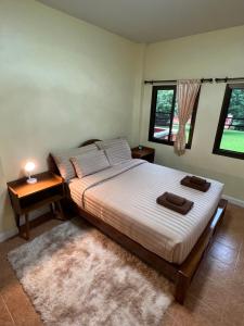 - une chambre avec un grand lit et 2 fenêtres dans l'établissement ViangPhing Resort, à Mae Chan