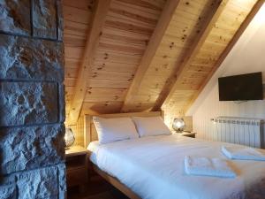 a bed in a room with a stone wall at View of the Durmitor in Žabljak