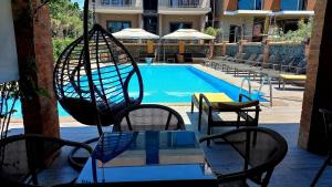 un tavolo e delle sedie accanto a una piscina di IVERIA BEACH a Kobuleti
