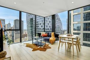 een woonkamer met een bank en een tafel bij Collins House - Melbourne Cbd Amazing view in Melbourne