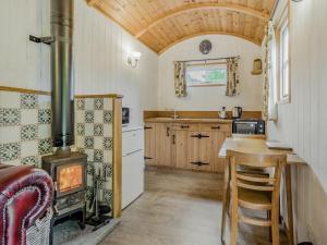a kitchen with a wood stove and a table at Shepherds Retreat - Uk45531 in Buildwas