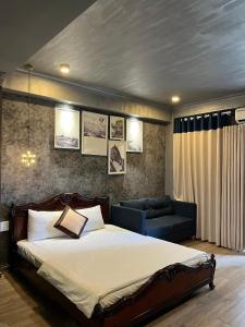 a bedroom with a large bed and a couch at Happy Hotel in Ho Chi Minh City