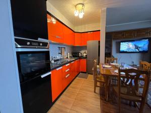 une cuisine avec des armoires orange et une table à manger dans l'établissement City view + location, à Oulan-Bator