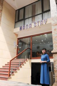 a woman standing in front of a building at HANA Stay in Hanoi