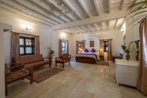 a bedroom with a bed and a couch and chairs at ama Stays & Trails Skanda , Coorg in Madikeri