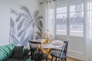 卡昂的住宿－Superbe appart chic, hyper centre, vue château, Parking inclus，一间带桌椅和窗户的用餐室