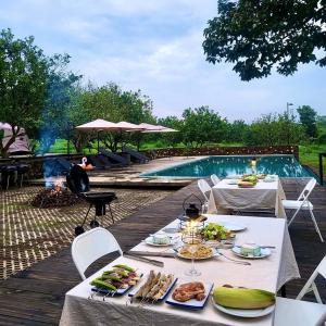 a table with plates of food next to a pool at Suối Camp in Bà Rịa +133 photos