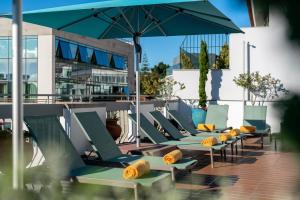 - une rangée de chaises et un parasol sur la terrasse dans l'établissement Hotel Madeira, à Funchal