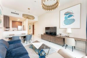 un salon avec un canapé bleu et une salle à manger dans l'établissement Fanciable 2BR Apartment & 1 Maids room in Avani Tower, à Dubaï