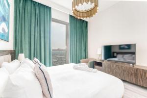 Fanciable 2BR Apartment & 1 Maids room in Avani Tower في دبي: غرفة نوم بسرير ابيض ونافذة كبيرة