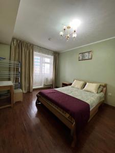 - une chambre avec un grand lit et un lustre dans l'établissement City view + location, à Oulan-Bator