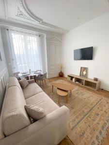 ein Wohnzimmer mit einem Sofa und einem Tisch in der Unterkunft Tour Eiffel/Luxury apartment n°6 in Paris