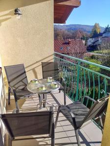 a patio with a table and chairs on a balcony at Apartament Perłowy 2 - z antresolą i widokiem - Dream Apart in Ustroń
