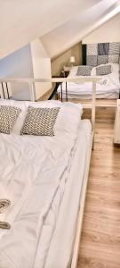 two beds are in a room with a table at Apartament Perłowy 2 - z antresolą i widokiem - Dream Apart in Ustroń