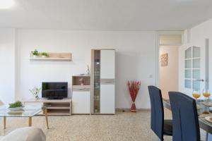een woonkamer met een tafel en een televisie bij LUMINOSO APARTAMENTO/ 5 MINUTOS DE LA PLAYA in Málaga