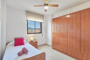 een slaapkamer met een bed en een grote houten kast bij LUMINOSO APARTAMENTO/ 5 MINUTOS DE LA PLAYA in Málaga