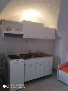 - une cuisine avec des placards blancs et un évier dans l'établissement Casa Anna, à Borgio Verezzi