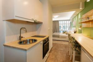 uma cozinha com um lavatório e uma cozinha com uma cama em Phaedrus Living: The Emerald Studio em Atenas