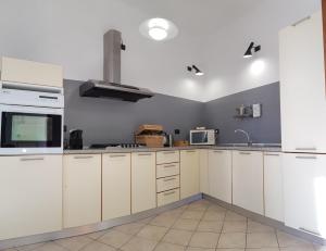 a kitchen with white cabinets and a sink at La Terrazza Apartment,a 50 mt dal mare in Varazze