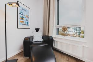 a black chair in a room with a window at Śląska Studio with Parking & Gym Business District Gdańsk by Renters in Gdańsk