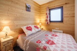 um quarto com uma cama num chalé de madeira em Le Petit Bonheur em Modane