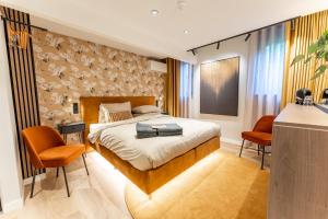 a bedroom with a bed and two orange chairs at Boetiekhotel Faan - NIEUW! in Ballum