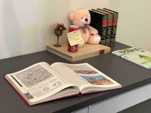 a book on a desk with a teddy bear and books at My home in Athens