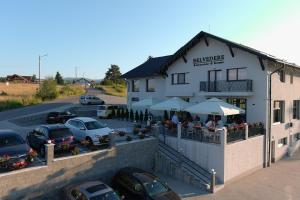 a building with cars parked in a parking lot at Belvedere Restaurant & Rooms in Topliţa
