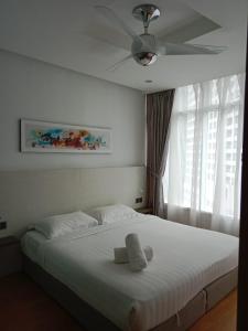 a bedroom with a white bed with a ceiling at Vortex Suites KLCC By Neptune in Kuala Lumpur