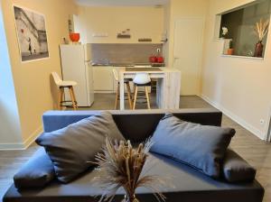 a living room with a couch and a kitchen at Logis Dans La Place Appartement in Thouarcé