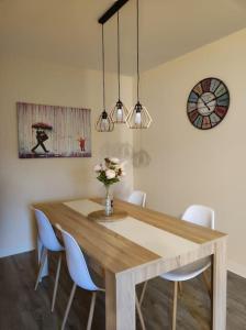 a dining room table with chairs and a vase of flowers at Logis Dans La Place Appartement in Thouarcé