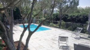 una piscina con due sedie e una recinzione di Maison De Vacances, Centre Var a Camps-la-Source