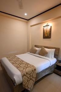 a bedroom with a large bed in a room at Little Chef Hotel in Kānpur