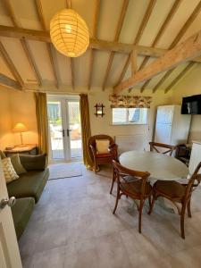 a living room with a table and a couch at The Calf Shed - cozy cottage in peaceful Norfolk countryside in Aldeby