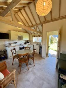 a kitchen with a table and chairs in a room at The Calf Shed - cozy cottage in peaceful Norfolk countryside in Aldeby