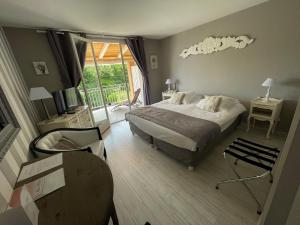 una camera con un letto e una sedia e una finestra di HOTEL LE MAS D'HèLèNE a Crestet