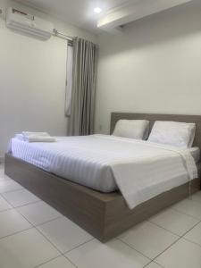 a bedroom with a large bed with white sheets and pillows at Moon and Sun Villa in Phnom Penh