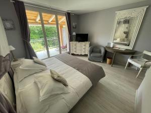 1 dormitorio con cama, escritorio y espejo en HOTEL LE MAS D'HèLèNE, en Crestet