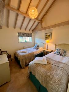 a bedroom with two beds in a room at The Calf Shed - cozy cottage in peaceful Norfolk countryside in Aldeby