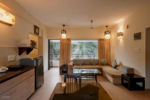 a living room with a couch and a table at La Sunila Suites & Villas by WSI, Baga in Baga